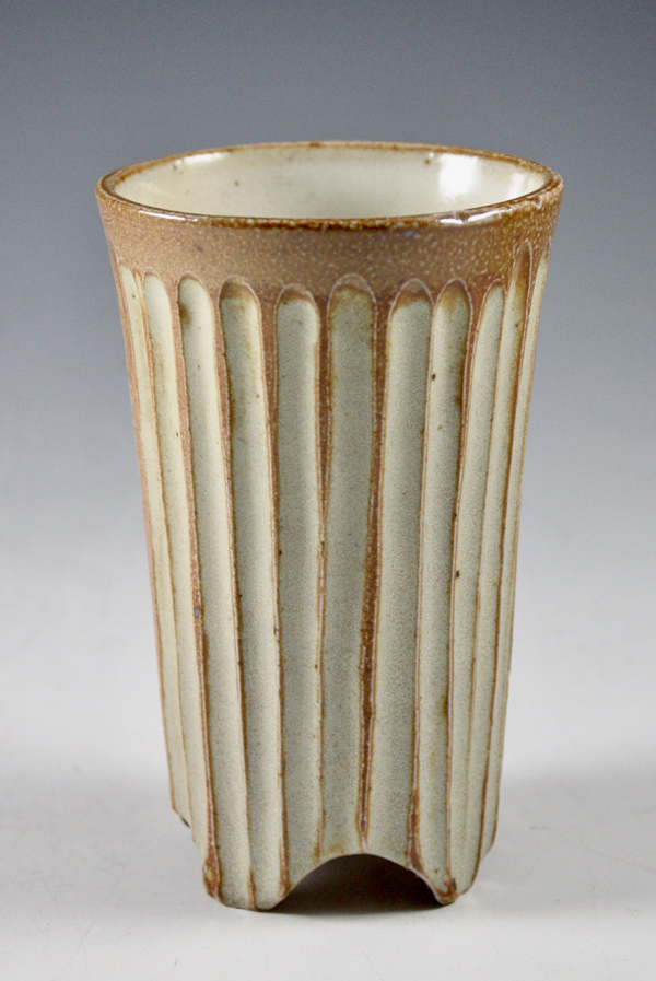 Debra Britt: Fluted tumbler with feet, 5 1/8 in. (13 cm) in height, clay, fired to cone 10 in a salt kiln, 2022.