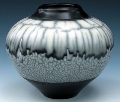 Naked Raku Orb by Charles and Linda Riggs, 2003. 7 in. (18 cm) in width. Stoneware painted with white terra sigillata and polished with a soft cloth, bisque fired to cone 010, covered in resist slip and glaze. Sgraffito through glaze before raku firing to 1400ºF (760°C).